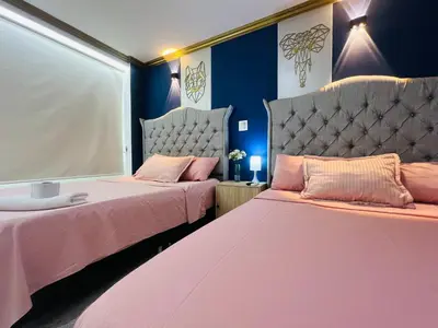 two beds in a room with pink and blue walls at Casa de Lujo en Condominio Privado por habitaciones in Cartagena de Indias