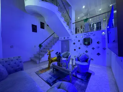 a living room with purple walls and a staircase at Casa de Lujo en Condominio Privado por habitaciones in Cartagena de Indias