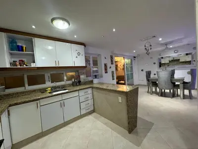 a kitchen with white cabinets and a dining room at Casa de Lujo en Condominio Privado por habitaciones in Cartagena de Indias
