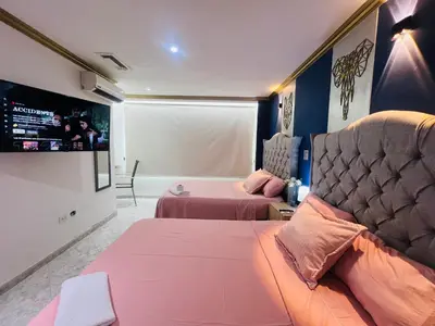 a bedroom with two beds and a tv on the wall at Casa de Lujo en Condominio Privado por habitaciones in Cartagena de Indias