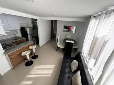 a living room with a couch and a kitchen at Apto amoblado en Alameda del Río in Barranquilla