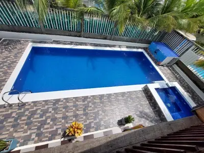 a large blue swimming pool next to a building at Sharick Beach House in Tubará