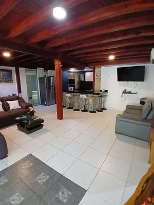 a large living room with a couch and a tv at Sharick Beach House in Tubará