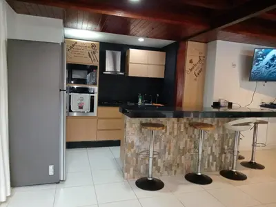 a kitchen with a bar with stools in it at Sharick Beach House in Tubará