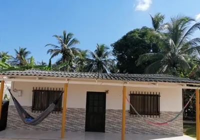 a house with a hammock in front of it at Cabaña Moñitos cerca al mar e Isla Fuerte in Moñitos