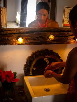 a woman is washing her hands in a sink at Mithival Beach Rincón del Mar in Rincón