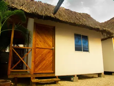 a small hut with a thatch roof and a door at Mithival Beach Rincón del Mar in Rincón