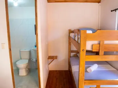 a small room with a bunk bed and a toilet at Mithival Beach Rincón del Mar in Rincón