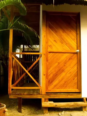 a wooden door on the side of a house at Mithival Beach Rincón del Mar in Rincón