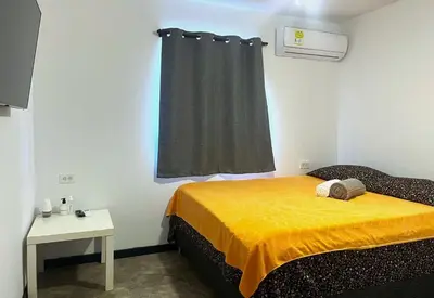 a bedroom with a bed with a yellow blanket and a window at Hotel Boutique Chateau de la Mar in Juan de Acosta