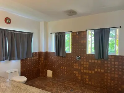 a bathroom with a brick wall and a toilet at Hotel Boutique Chateau de la Mar in Juan de Acosta