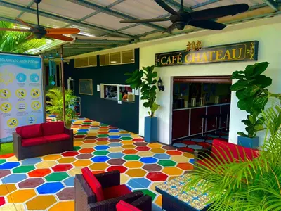 a lobby with a colorful floor with chairs and a coffee shop at Hotel Boutique Chateau de la Mar in Juan de Acosta