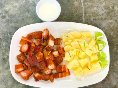 a plate of food with potatoes and pineapple on a table at Hotel Boutique Chateau de la Mar in Juan de Acosta