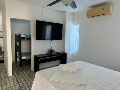 a bedroom with a bed and a flat screen tv at Hotel Boutique Chateau de la Mar in Juan de Acosta