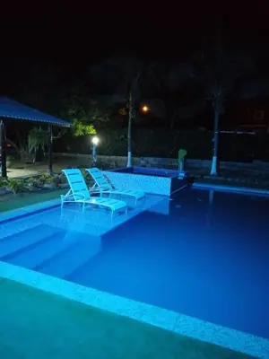 a swimming pool at night with two lounge chairs at Espectacular Cabaña en Santa Veronica in Santa Veronica