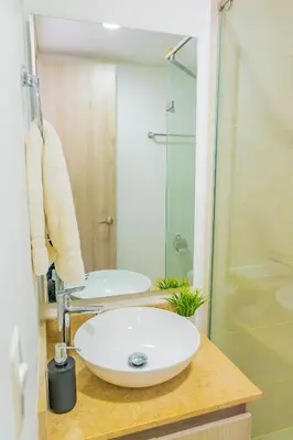 a bathroom with a sink and a glass shower at U-GO Ocean Drive: Apto Moderno con Balcón y Mar in Cartagena de Indias