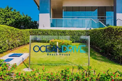 a sign in the grass in front of a house at U-GO Ocean Drive: Apto Moderno con Balcón y Mar in Cartagena de Indias