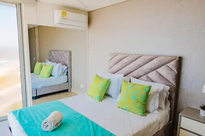 a bedroom with a bed with a large window at U-GO Ocean Drive: Apto Moderno con Balcón y Mar in Cartagena de Indias