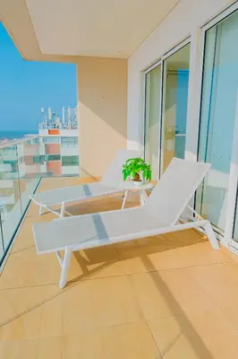 a balcony with white chairs and a table on a building at U-GO Edificio H2 en Bocagrande Frente al Mar in Cartagena de Indias