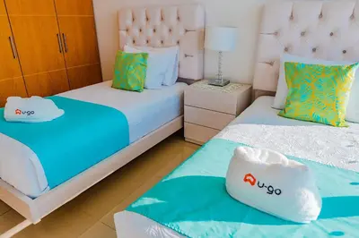 a bedroom with two beds and a night stand at U-GO Edificio H2 en Bocagrande Frente al Mar in Cartagena de Indias