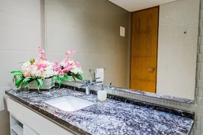 a bathroom with a sink and flowers on a counter at U-GO Edificio H2 en Bocagrande Frente al Mar in Cartagena de Indias