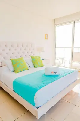 a large white bed in a white room with at U-GO Edificio H2 en Bocagrande Frente al Mar in Cartagena de Indias