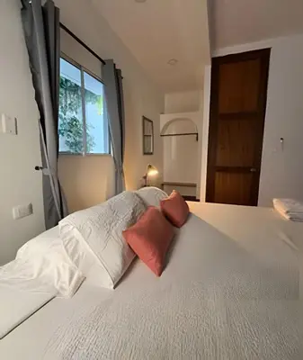 a bedroom with a large white bed with a window at Céntrico y confortable apto Casa Doña yola 7 in Cartagena de Indias