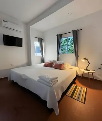 a white bedroom with a large bed and a window at Céntrico y confortable apto Casa Doña yola 7 in Cartagena de Indias