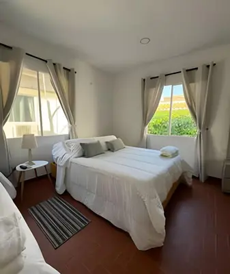 a white bedroom with two beds and a window at Céntrico y confortable apto Casa Doña yola 8 in Cartagena de Indias