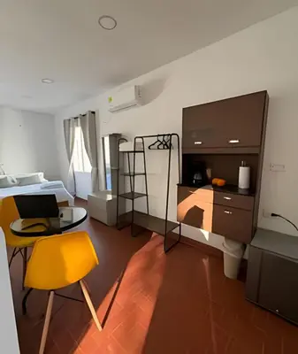 a bedroom with a bed and a table and a yellow chair at Céntrico y confortable apto Casa Doña yola 8 in Cartagena de Indias