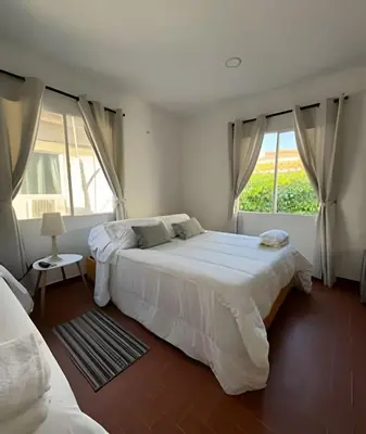 a white bedroom with two beds and a window at Céntrico y confortable apto Casa Doña yola 8 in Cartagena de Indias