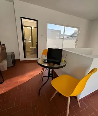 a room with a table and yellow chairs and a laptop at Céntrico y confortable apto Casa Doña yola 8 in Cartagena de Indias