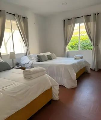 two beds in a room with two windows at Céntrico y confortable apto Casa Doña yola 8 in Cartagena de Indias