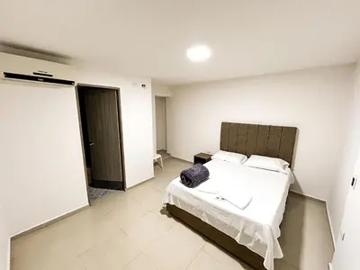 a bedroom with a bed and a door to a room at Hotel & Restaurante Oasis CTG in Cartagena de Indias
