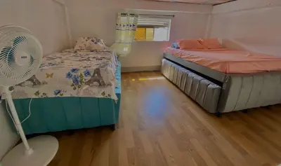 a small bedroom with a bed and a fan at Aparta Hotel Manzur in Barranquilla
