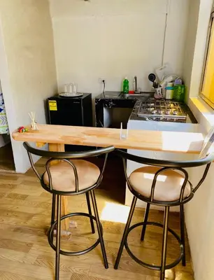 a kitchen with two bar stools and a counter top at Aparta Hotel Manzur in Barranquilla