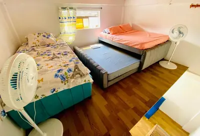 a small room with two beds and a fan at Aparta Hotel Manzur in Barranquilla
