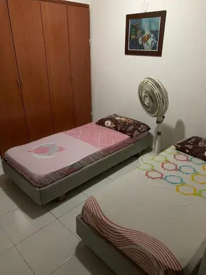 two twin beds in a room with a fan at Habitacion Medusa in Barranquilla