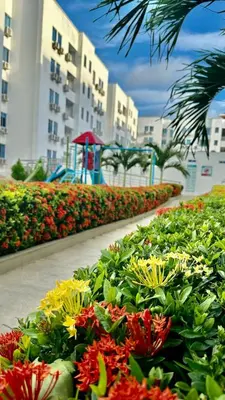 a garden of flowers with a playground in the background at Apartamento de descanso Om Shanti Om in Coveñas