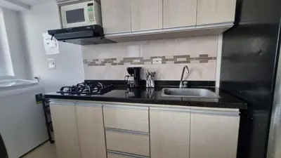 a small kitchen with a sink and a microwave at Apartamento de descanso Om Shanti Om in Coveñas