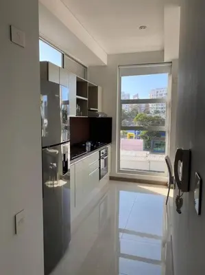 a white kitchen with a large window and a counter at Apartaestudio Jacuzzi Centro Comercial Gimnasio ALTOPRADO in Barranquilla