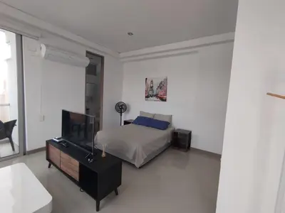 a bedroom with a bed and a flat screen tv at Apartaestudio Jacuzzi Centro Comercial Gimnasio ALTOPRADO in Barranquilla