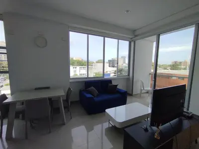 a living room with a blue couch and a table at Apartaestudio Jacuzzi Centro Comercial Gimnasio ALTOPRADO in Barranquilla