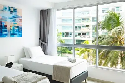 a hotel room with two beds and a large window at Apartamento 2 Dormitorios Morros. Salida playa in Cartagena de Indias