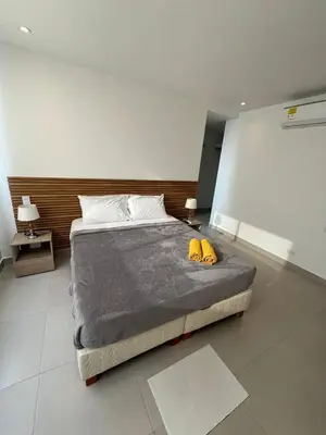 a bedroom with a large bed with two yellow shoes on it at Encanto Rentals at Sunno Beach in Cartagena de Indias