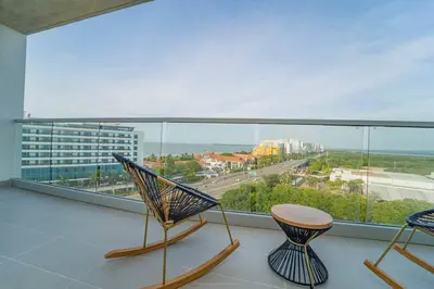 a balcony with two chairs and a view of a city at Encanto Rentals at Sunno Beach in Cartagena de Indias