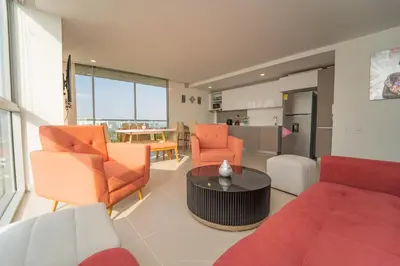 a living room with orange chairs and a table at Encanto Rentals at Sunno Beach in Cartagena de Indias