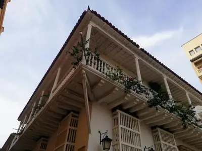 a building with a balcony with flowers on it at Cartagena más cómoda y económica in Cartagena de Indias