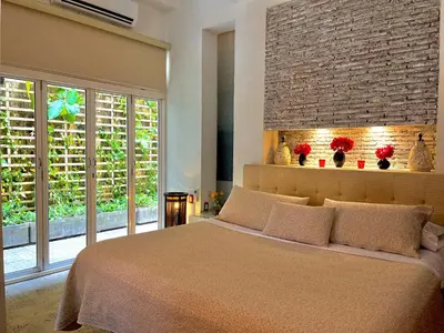 a bedroom with a large bed and a brick wall at by Calamari Homes - Parque Centenario 206 walled city in Cartagena de Indias