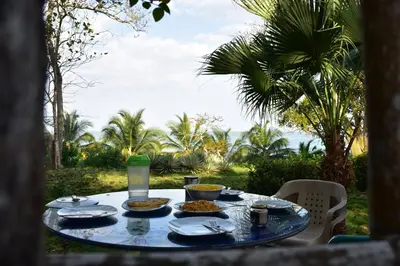 a table with plates and bowls of food on it at Pajarito Eco-Lodge frente al mar in Cedro